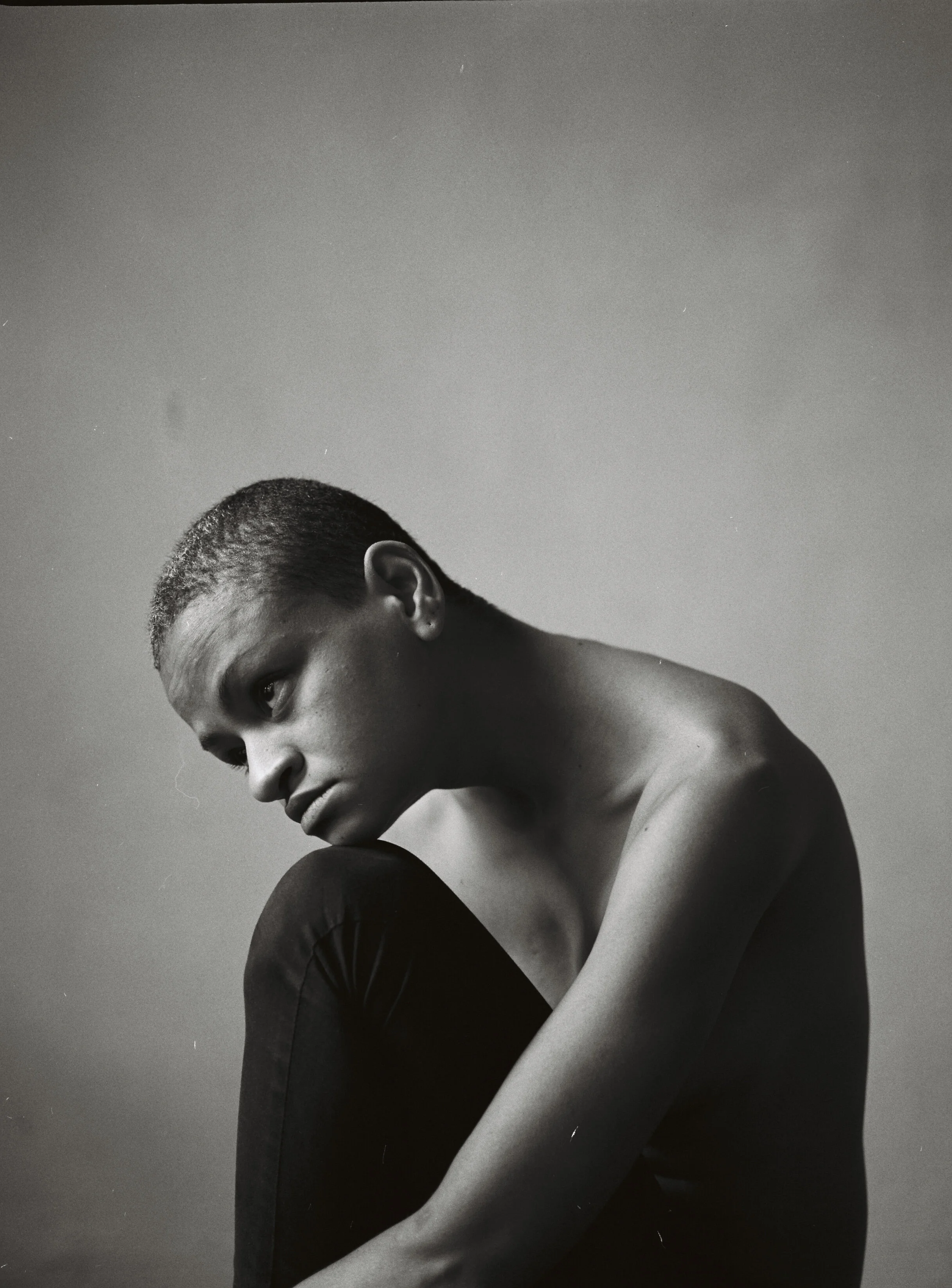 Black-and-white portrait of Mirelle Martins seated with one knee raised