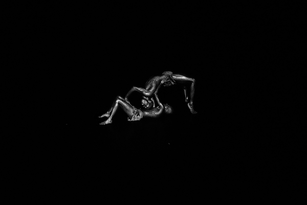 Two silver-painted performers in a mirrored arch on a dark stage